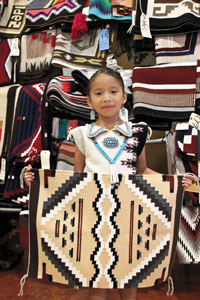 Adorable picture #2 of little girl holding up a Navajo Rug